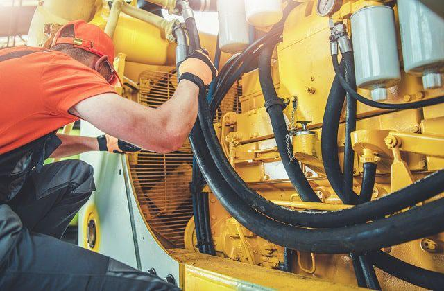 Technician commissioning industrial equipment with digital checklist on site