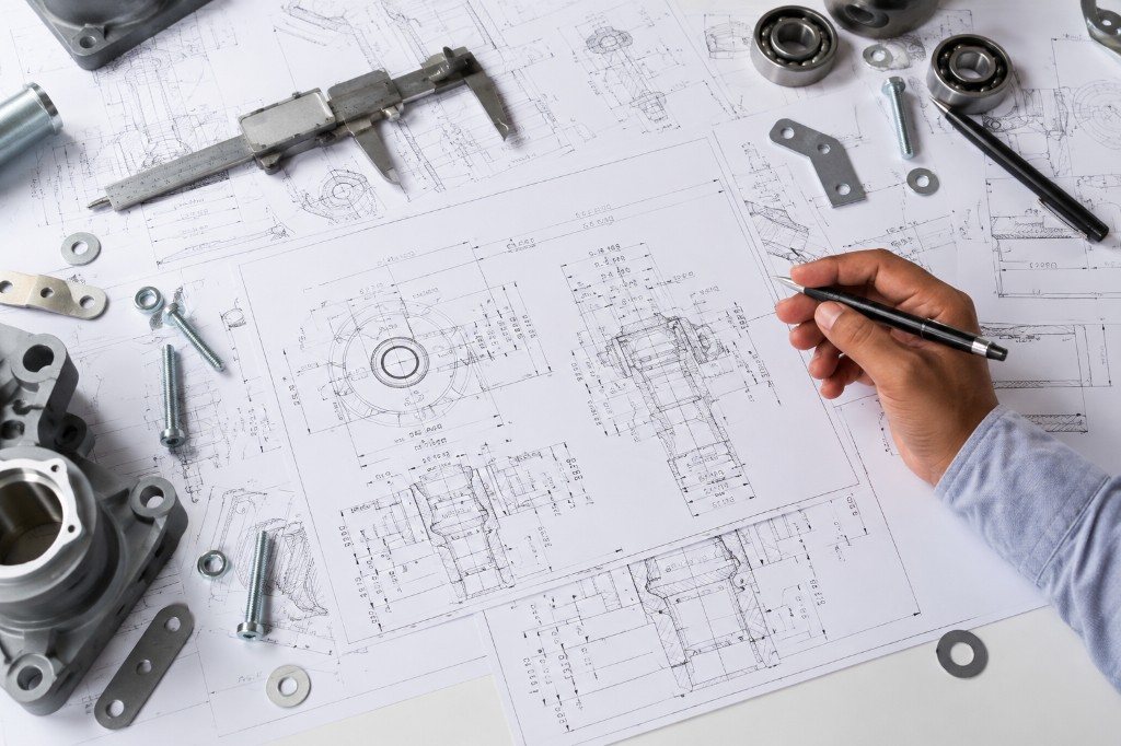 Engineer inspecting and adjusting industrial machinery controls on site